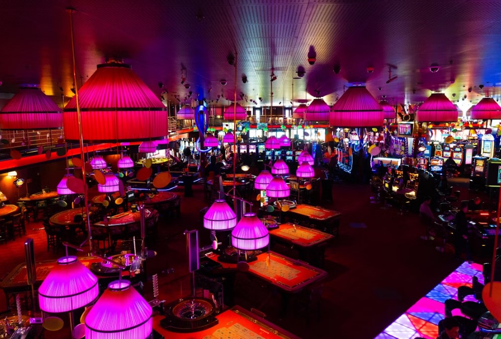 From Screen to Casino Floor: Celebs Who Own or Promote Casinos & Gaming Brands 2 A fancy casino with dim lighting and purple chandeliers