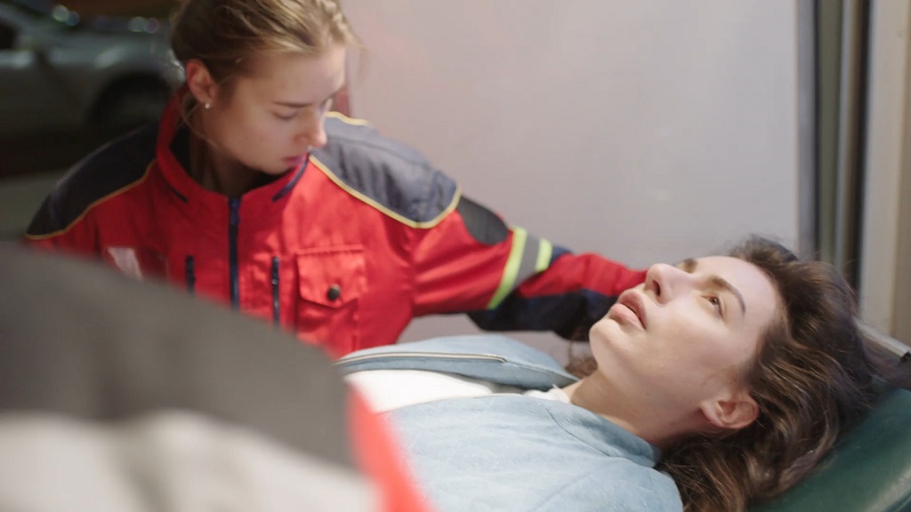 Emergency medical responder assisting a patient on a stretcher, highlighting the importance of preparation for medical care abroad