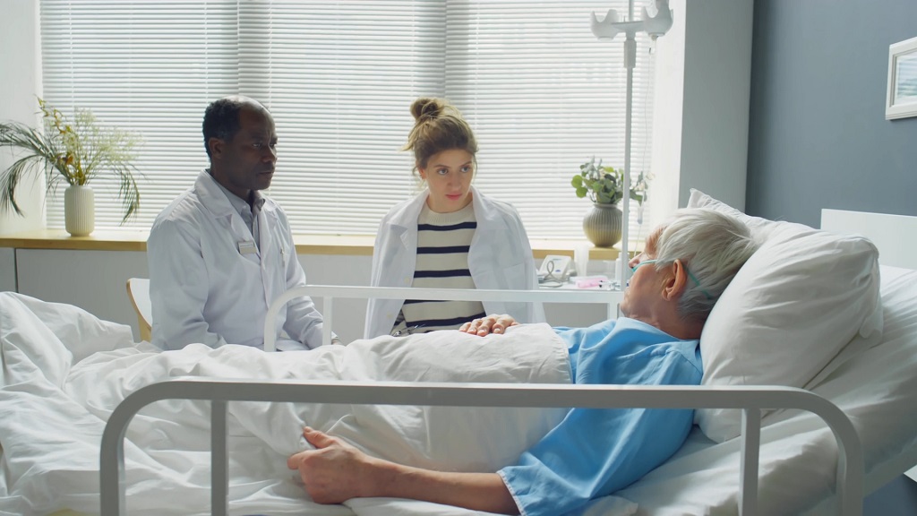 Doctors speaking with a hospitalized patient, emphasizing clear communication during medical visits when language barriers exist